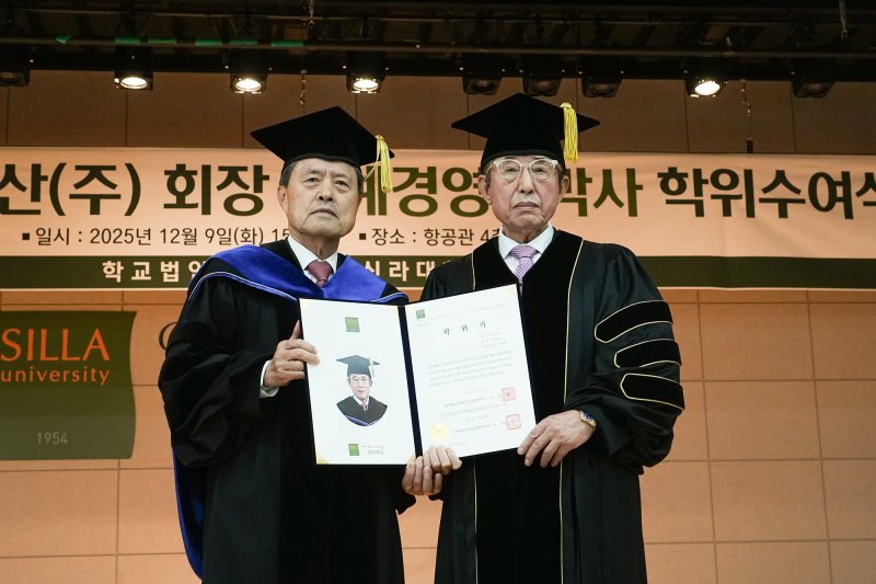 [부산=뉴시스] 신라대학교는 9일 오후 부산 사상구 대학 내 항공관에서 희창물산 권중천(오른쪽) 회장에게 명예경영학박사 학위를 수여했다고 9일 밝혔다. (사진=신라대 제공) 2025.12.09. photo@newsis.com *재판매 및 DB 금지