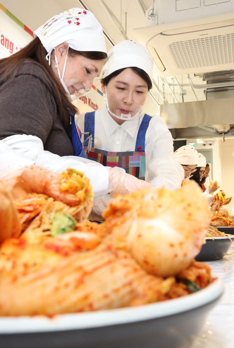 [서울=뉴시스] 고범준 기자 = 김혜경 여사가 9일 서울 종로구 북촌 한식문화공간 이음에서 열린 주한대사 배우자 초청 김장 행사에서 주한 외국대사 배우자들과 함께 김치를 담그고 있다. 2025.12.09. bjko@newsis.com