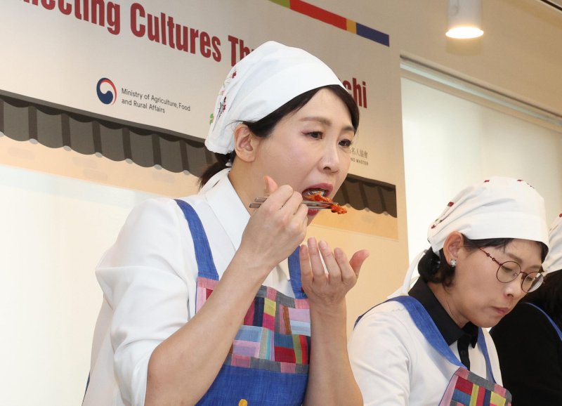 [서울=뉴시스] 고범준 기자 = 김혜경 여사가 9일 서울 종로구 북촌 한식문화공간 이음에서 열린 주한대사 배우자 초청 김장 행사에서 김치를 시식하고 있다. 2025.12.09. bjko@newsis.com