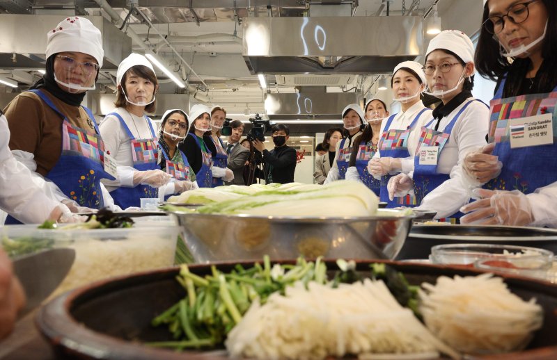 [서울=뉴시스] 고범준 기자 = 김혜경 여사가 9일 서울 종로구 북촌 한식문화공간 이음에서 열린 주한대사 배우자 초청 김장 행사에서 주한 외국대사 배우자들과 함께 이하연 명인의 설명을 듣고 있다. 2025.12.09. bjko@newsis.com