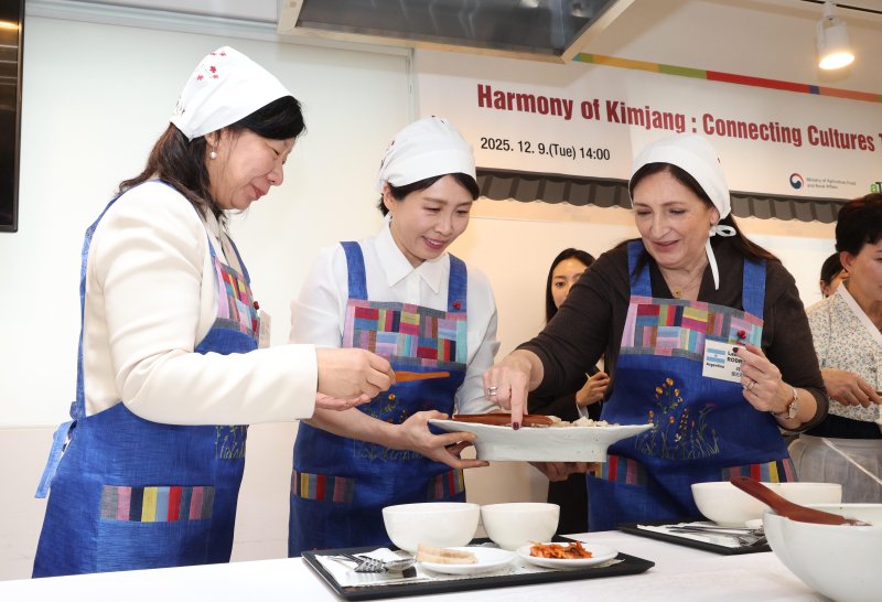 [서울=뉴시스] 고범준 기자 = 김혜경 여사가 9일 서울 종로구 북촌 한식문화공간 이음에서 열린 주한대사 배우자 초청 김장 행사에서 주한 외국대사 배우자들에게 보쌈을 나눠주고 있다. 2025.12.09. bjko@newsis.com