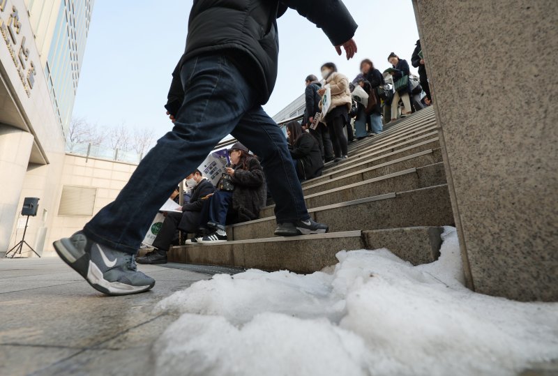 [서울=뉴시스] 김진아 기자 = 7일 서울 종로구 성균관대학교 600주년 기념관에서 열린 종로학원 주최 2026 정시 합격 가능선 예측 및 지원전략 설명회에 들어가지 못한 참석자들이 야외 계단에 앉아 설명회를 듣고 있다. 2025.12.07. bluesoda@newsis.com