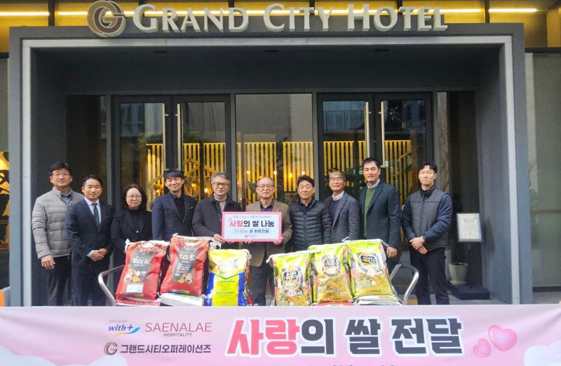 그랜드시티호텔 창원 이은호 대표(왼쪽 네번째)와 호텔, 장애인 직업재활시설 관계자들이 ‘사랑의 쌀 나눔’ 행사에서 기념촬영을 하고 있다. 그랜드시티호텔 창원 제공