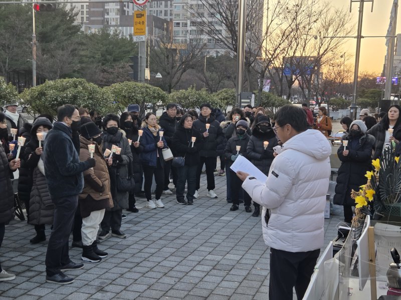 [전주=뉴시스] 강경호 기자 = 9일 전북 전주시 전북특별자치도청 앞 인도에서 전주 자임추모공원에 유골함을 안치한 유족들이 대책 논의를 위해 마련된 촛불집회에 참석해 송인현 자임유가족협의회 공동대표의 발언을 듣고 있다. 2025.12.09. lukekang@newsis.com