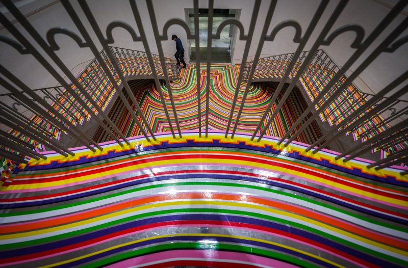 [밴쿠버=AP/뉴시스] 8일(현지 시간) 캐나다 밴쿠버의 밴쿠버 아트 갤러리에서 한 방문객이 예술가이자 음악가인 짐 램비의 전시 ‘조밥·컬러크롬'(Zobop·Colour-Chrome)이 설치된 계단을 오르고 있다. 착시 현상을 일으키는 바닥 설치 작품으로 유명한 램비의 이번 전시도 갤러리 계단과 홀 바닥에 설치됐다. 2025.12.09.