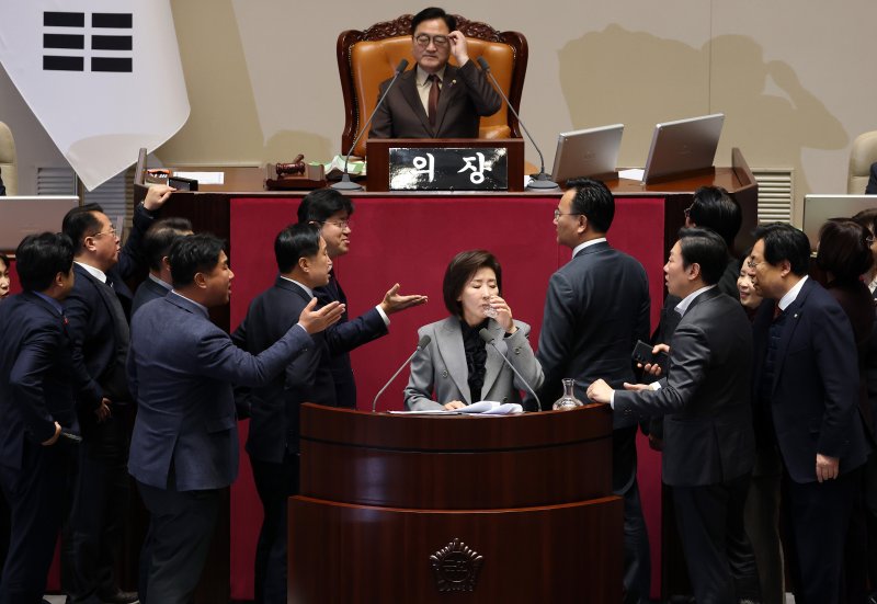 국민의힘 나경원 의원(가운데)이 9일 국회 본회의에서 '가맹사업거래의 공정화에 관한 법률 일부개정법률안'에 대해 필리버스터에 나선 가운데 여야 의원들이 발언대 양쪽에서 신경전을 벌이고 있다. 국민의힘은 이날 상정된 법안 62건 중 3건만 합의처리하고 나머지는 필리버스터를 하기로 했다. 연합뉴스