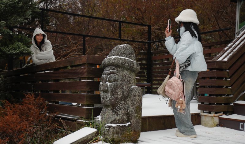 [제주=뉴시스] 우장호 기자 = 지난달 18일 오전 외국인 관광객들이 첫 눈이 쌓인 제주 한라산 1100고지 휴게소 앞에서 기념사진을 찍고 있다. 2025.11.18. woo1223@newsis.com