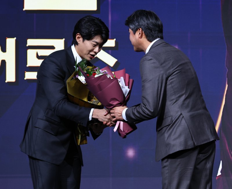 [서울=뉴시스] 최진석 기자 = 키움 히어로즈 송성문이 9일 서울 송파구 롯데호텔 월드에서 열린 '2025 KBO 골든글러브 시상식'에서 3루수 골든글러브를 수상한 뒤 꽃다발을 받고 있다. 2025.12.09. myjs@newsis.com