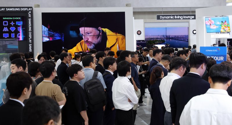 7일 서울 강남구 코엑스에서 열린 2025 한국디스플레이산업 전시회에서 관람객들이 전시물을 둘러보고 있다. 올해 전시는 올해는 유기발광다이오드(OLED) 분야를 선도하고 있는 국내 양대 패널 기업과국내·외 소부장 기업들이 대거 참여해 미래 디스플레이 기술의 방향을 제시한다. 2025.8.7/뉴스1 ⓒ News1 김명섭 기자