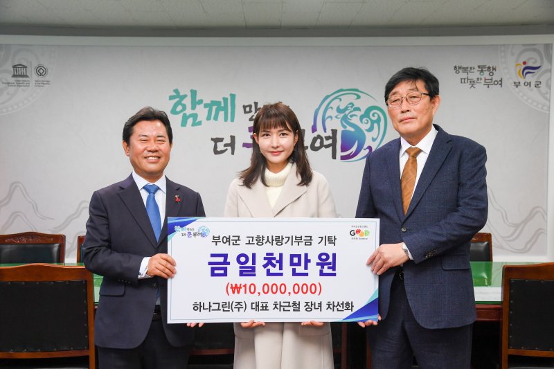 부여 출신 차선화 씨(가운데)가 군에 1000만 원을 지정 기탁하고 기념촬영을 하고 있다.(부여군 제공. 재판매 및 DB금지)/뉴스1