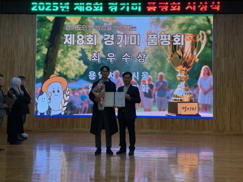 오시웅 농업인(왼쪽)이 지난 9일 경기도농업기술원에서 열린 제8회 경기미품평회에서 청품벼를 출품해 최우수상을 받은 뒤 기념촬영을 하고 있는 모습.(용인시 제공)