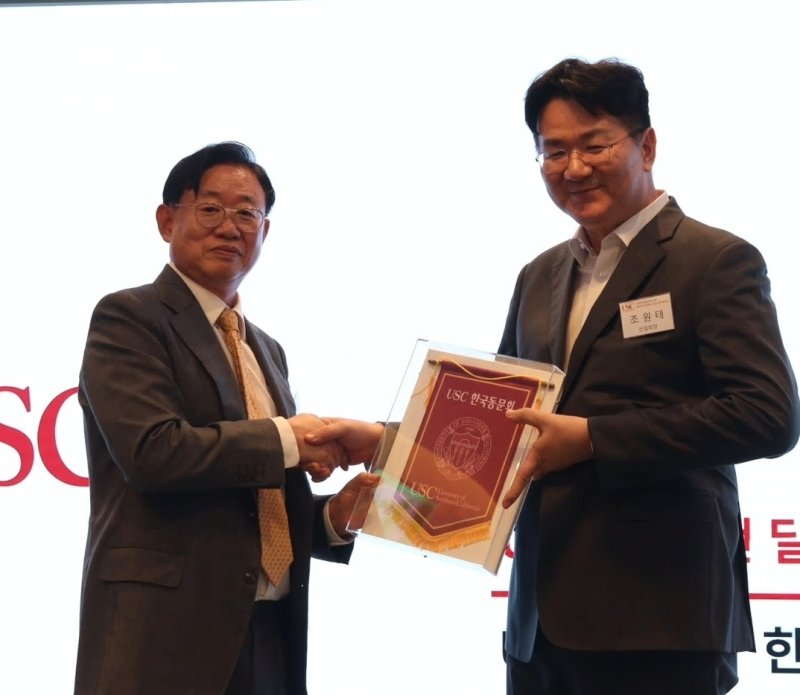 조원태 한진그룹 회장(오른쪽)이 1일 서울 강남의 호텔에서 열린 미국 서던캘리포니아대(USC) 한국 총동문회 송년회에서 권순욱 총동문회장(왼쪽)으로부터 총동문회기를 넘겨받고 있다. 이날 조 회장은 신임 USC 한국 총동문회장으로 선임됐다(인스타그램 'usc.korea.official' 갈무리). 2025.12.01.