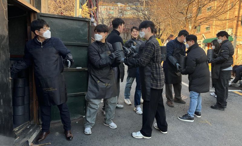 대한해운 임직원들이 지난 9일 서울 마포구 연남로 일대에서 인근 주민들에게 직접 연탄을 전달하는 '이웃사랑 연탄 나누기 봉사활동'을 펼치고 있다. SM그룹 제공