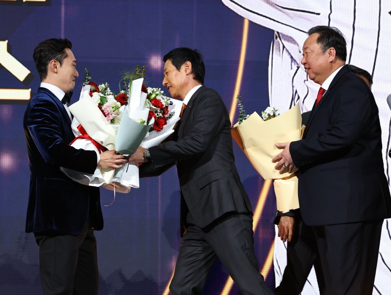 [서울=뉴시스] 최진석 기자 = LG 트윈스 신민재가 9일 서울 송파구 롯데호텔 월드에서 열린 '2025 KBO 골든글러브 시상식'에서 2루수 골든글러브를 수상하며 염경엽 감독, 차명석 단장의 꽃다발을 받고 있다. 2025.12.09. myjs@newsis.com