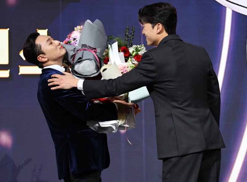 [서울=뉴시스] 최진석 기자 = LG 트윈스 신민재가 9일 서울 송파구 롯데호텔 월드에서 열린 '2025 KBO 골든글러브 시상식'에서 2루수 골든글러브를 수상하며 박해민의 꽃다발을 받고 있다. 2025.12.09. myjs@newsis.com