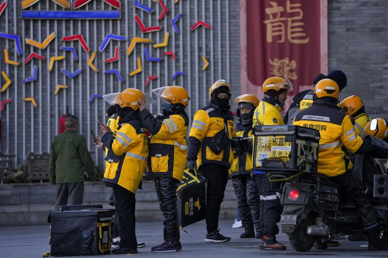 [베이징=AP/뉴시스] 11월 중국 소비자물가지수(CPI)가 전년 동월 대비 0.7% 상승했다고 10일 중국 국가통계국이 발표했다. 사진은 지난해 1월 5일 중국 베이징에서 배달플랫폼 메이퇀의 배달원들이 거리에 모여 있는 모습. 2025.12.10