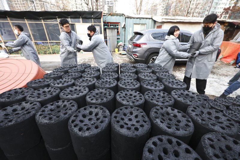 [서울=뉴시스] 김근수 기자 = 공감언론 뉴시스 임직원들과 대한장애인체육회 임직원들이 10일 오전 서울 강남구 구룡마을에서 공감언론 뉴시스와 함께하는 2025년 대한장애인체육회 사랑의 연탄 나눔 봉사활동을 하고 있다. 2025.12.10. ks@newsis.com