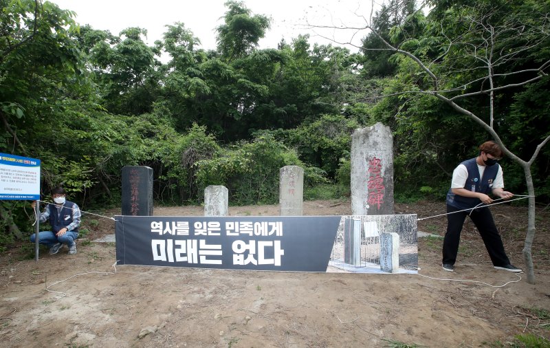 [제주=뉴시스] 제주도보훈청 관계자들이 2022년 5월20일 오후 제주시 한울누리공원 인근 도로변에 있는 박진경 추도비를 감싸고 있던 감옥 형태의 조형물을 철거하는 행정대집행을 진행했다. 이 조형물은 지난 3월 제주4·3기념사업위원회 등 16개 단체가 참여해 추도비를 '역사의 감옥에 가두다'는 의미로 설치했다. 조형물 설치에 참여했던 단체 관계자들이 '역사를 잊은 민족에게 미래는 없다'라고 적힌 현수막을 설치하는 모습. (사진=뉴시스 DB). photo@newsis.com