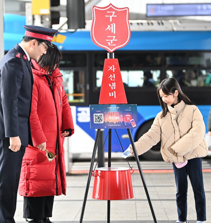 [수원=뉴시스] 김종택 기자 = 구세군 연말 모금 캠페인이 시작된 10일 경기 수원역에서 한 어린이가 구세군 자선냄비에 성금을 넣고 있다. 2025.12.10. jtk@newsis.com