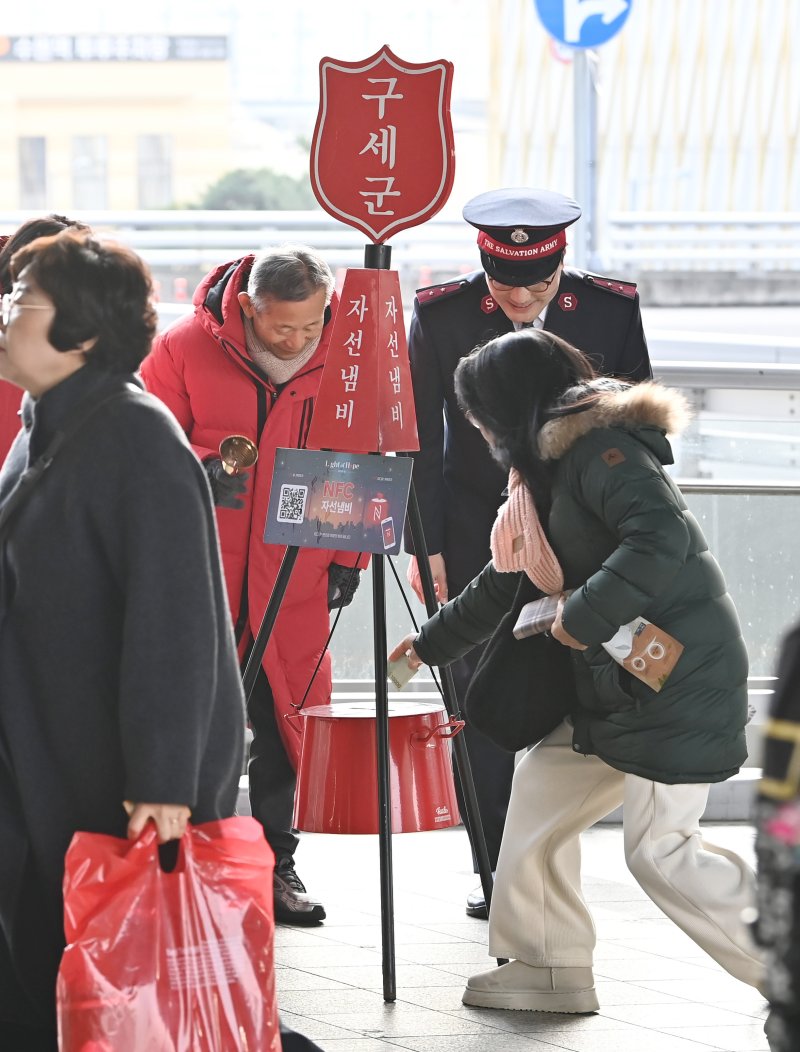 [수원=뉴시스] 김종택 기자 = 구세군 연말 모금 캠페인이 시작된 10일 경기 수원역에서 한 시민이 구세군 자선냄비에 성금을 넣고 있다. 2025.12.10. jtk@newsis.com