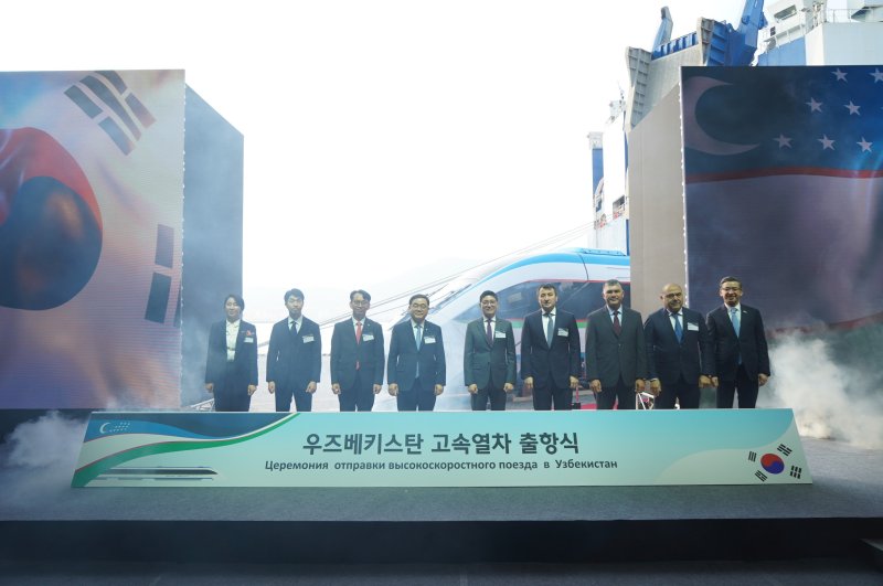 [창원=뉴시스]10일 오후 경남 창원시 성산구 마산항 제4부두에서 열린 현대로템의 우즈베키스탄 고속열차 출항식 주요 참석자들이 기념촬영하고 있다.(사진=현대로템 제공) 2025.12.10. photo@newsis.com