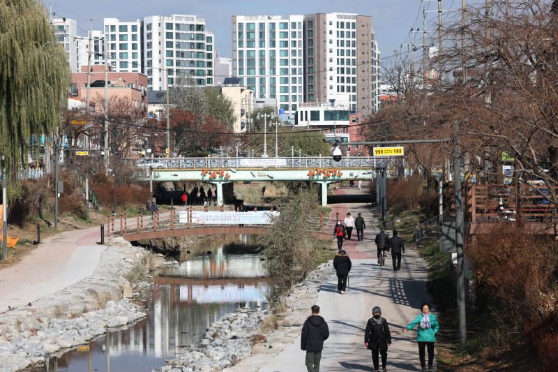 포근한 겨울 날씨를 보인 9일 경기 수원시 권선구 세류천에서 시민들이 산책을 즐기고 있다. 2025.12.9/뉴스1 ⓒ News1 김영운 기자