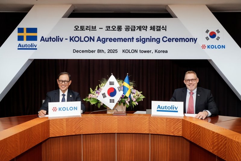 코오롱인더스트리가 8일 코오롱 과천 사옥에서 오토리브(Autoliv)와 에어백 소재를 추가 공급한다는 계약을 체결했다. 허성 코오롱인더스트리 사장과 크리스티안 스완 오토리브 오토리브 총괄 부사장이 계약을 체결하는 모습. (사진제공 = 코오롱인더스트리)