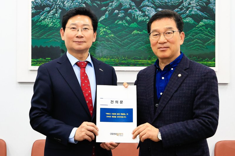 이상일 시장(왼쪽)이 지난 10일 신정훈 국회 행정안전위원회 위원장에게 '특례시 지원에 관한 특별법 제정 촉구 건의문'을 전달하고 있는 모습.(용인시 제공)