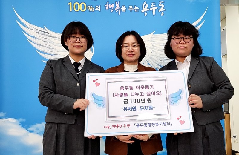 [제천=뉴시스] 이웃돕기 성금 맡기는 제천여고 유지원·서원 자매. (사진=제천시 제공) 2025.12.11. photo@newsis.com *재판매 및 DB 금지