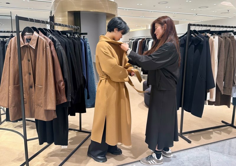 신세계백화점 센텀시티를 방문한 고객들이 모어 서울의 옷을 착용해 보고 있다.(신세계 센텀시티 제공. 재판매 및 DB 금지)