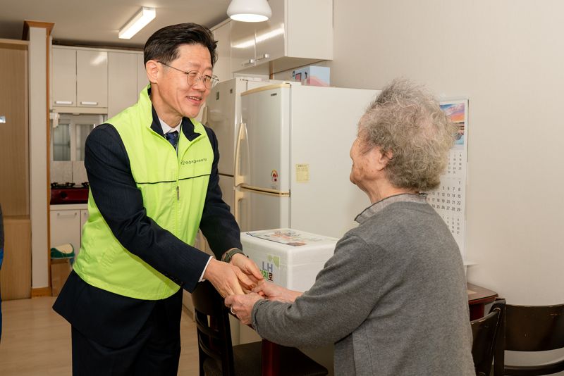 11일 안산 고향마을에서 열린 김치 나눔 행사에서 이상욱 LH 사장 직무대행(왼쪽)이 사할린 동포에게 김장김치를 전달하고 있다. LH 제공