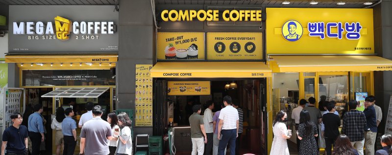 서울 시내에 위치한 저가 브랜드 커피 매장 앞에서 시민들이 줄지어 커피를 구매하고 있다. 2024.7.1/뉴스1 ⓒ News1 임세영 기자