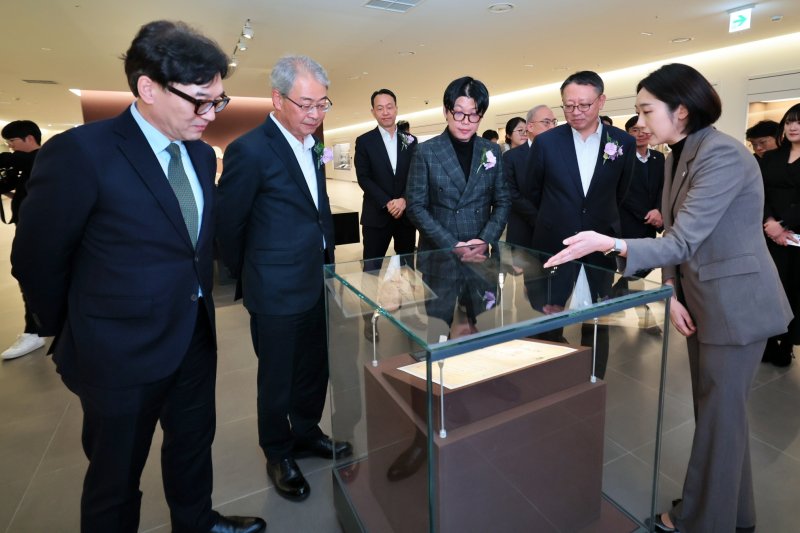 11일 서울 중구 우리은행 본점 지하 1층에 문을 연 '우리1899'에서 (왼쪽 두 번째부터)임종룡 우리금융그룹 회장, 이정섭 우리은행 상무, 고 박경리 작가의 외손자인 토지문화재단 김세희 이사장, 정진완 우리은행장이 대한천일은행 창립청원서에 대한 설명을 듣고 있다. (사진=우리금융 제공) *재판매 및 DB 금지