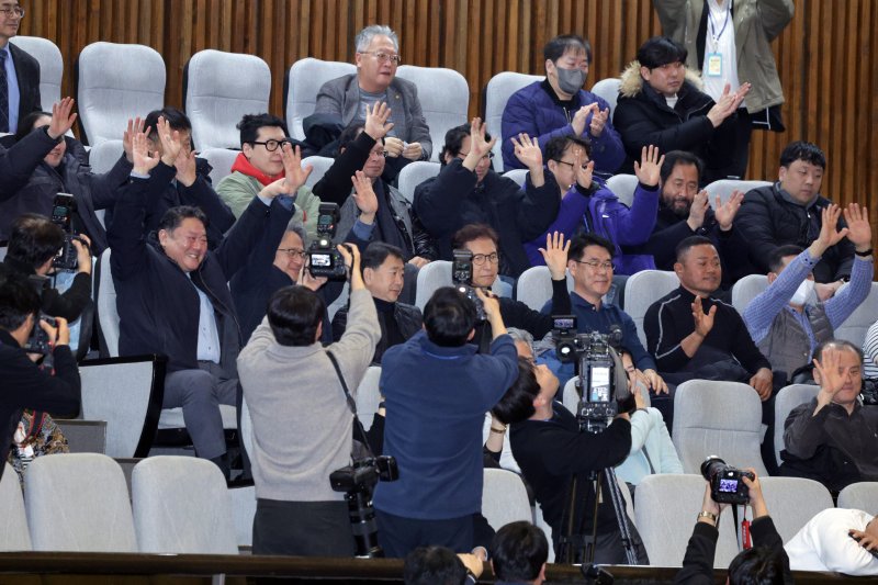 전국가맹점주협의회 회원들이 11일 서울 여의도 국회에서 열린 제430회국회(임시회) 제1차 본회의에서 가맹사업거래의 공정화에 관한 법률 일부개정법률안(원안)이 가결되자 환호하고 있다. 2025.12.11/뉴스1 ⓒ News1 신웅수 기자