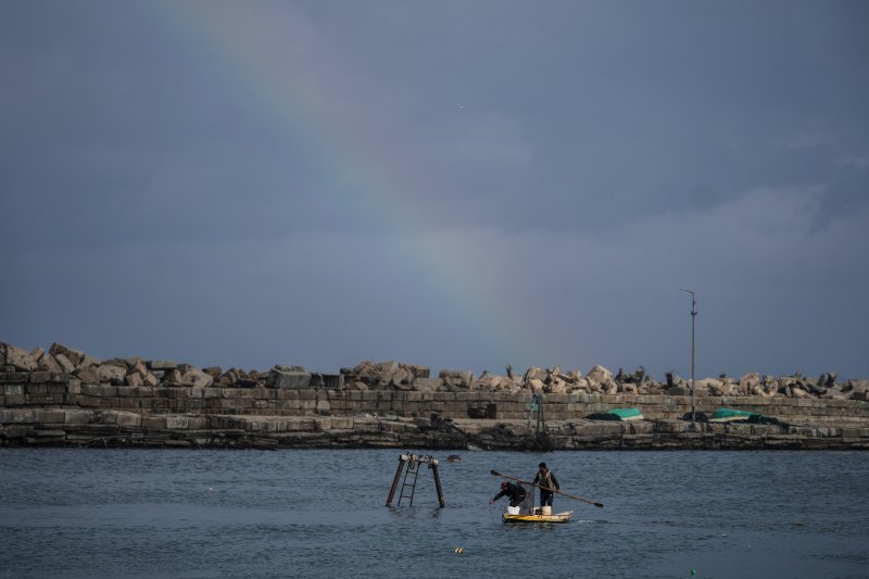 [가자시티=AP/뉴시스] 10일(현지 시간) 무지개가 뜬 가자지구 가자시티 항구에서 팔레스타인 주민들이 물고기를 잡고 있다. 2025.12.11.