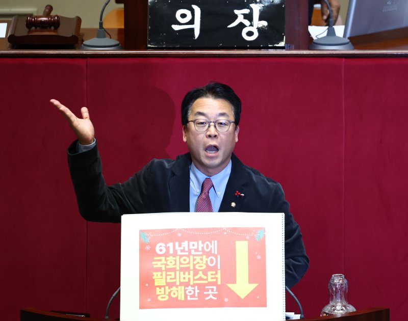 [서울=뉴시스] 김명년 기자 = 곽규택 국민의힘 의원이 11일 오후 서울 여의도 국회 본회의에서 형사소송봅 일부개정법률안에 대한 필리버스터(무제한 토론)를 하고 있다. 곽 의원은 지난번 본회의에서 벌어진 나경원 의원 토론 중단사태에 대해 항의하는 내용이 적힌 손피켓을 들고 토론에 나섰다. 2025.12.11. kmn@newsis.com