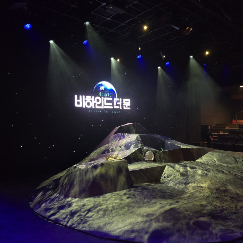 [사진=박현주 미술전문기자]뮤지컬 ‘비하인드 더 문’의 무대. 달 표면을 형상화한 단출한 조형물 위로 LED 영상과 조명이 투사돼, 소극장임에도 깊은 공간감을 구현한다. 2025.12.10. hyun@newsis.com *재판매 및 DB 금지