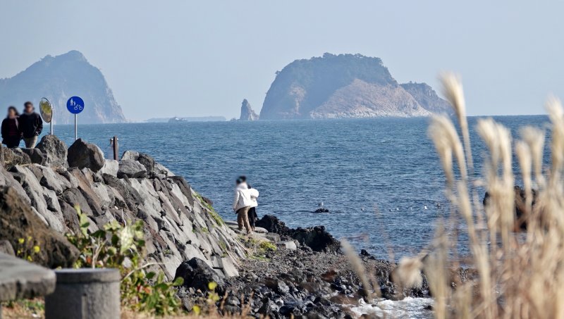 [제주=뉴시스] 오영재 기자 = 지난 7일 오전 제주 서귀포시 법환동 올레7코스 인근 해안가에서 관광객들이 즐거운 시간을 보내고 있다. 2025.12.07. oyj4343@newsis.com
