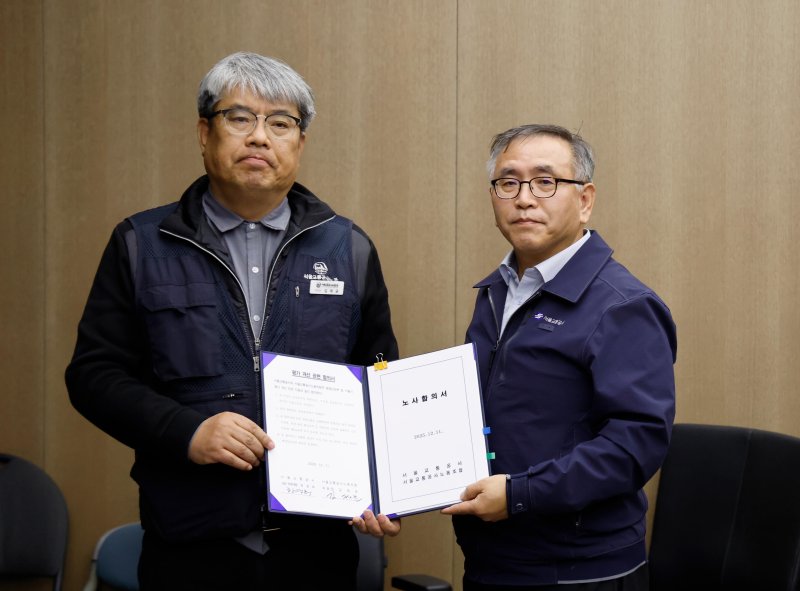 한영희(오른쪽) 서울교통공사 사장 직무대행이 12일 오전 서울 성동구 서울교통공사에서 김태균 민주노총 공공운수노조 서울교통공사노조위원장과 임금·단체협약을 체결한 뒤 기념촬영 하고 있다. 뉴시스화상