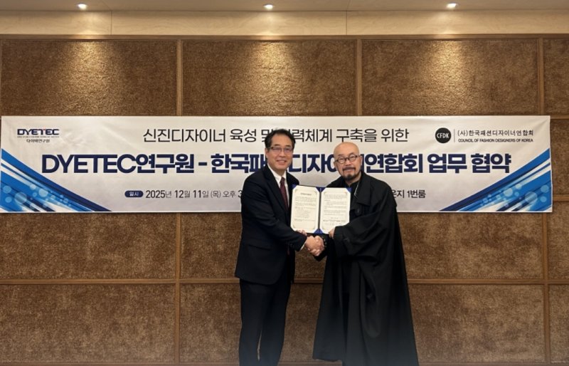 최재홍 다이텍연구원장(왼쪽)과 이상봉 한국패션디자이너연합회 회장이 신진 디자이너 육성 및 협력체계 구축을 위한 업무협약을 체결한 뒤 악수를 하고 있다.(다이텍연구원 제공, 재판매 및 DB 금지)