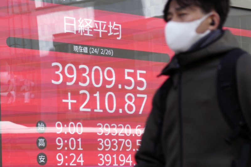 [도쿄=AP/뉴시스]지난해 4월 일본 도쿄에서 한 시민이 도쿄증시 닛케이평균주가(닛케이지수)를 보여주는 증권사 전광판 앞을 지나가고 있다. 2025.12.12.