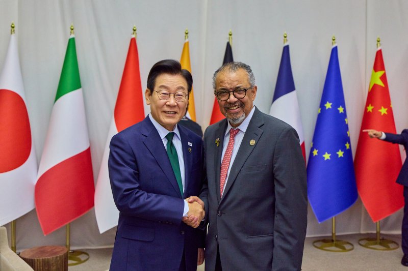 [요하네스버그=뉴시스] 최동준 기자 = 이재명 대통령이 11월 23일 남아프리카공화국 요하네스버그 엑스포 센터에서 열린 G20 정상회의에서 테워드로스 아드하놈 거브러여수스 세계보건기구(WHO) 사무총장과 양자 회담 중 기넘촬영을 하고 있다. (공동취재) 2025.12.12.