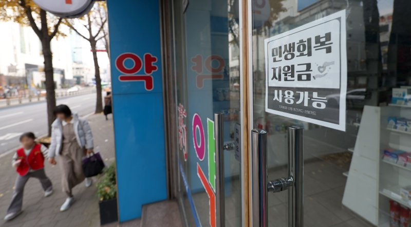 [서울=뉴시스] 김선웅 기자 = 30일 서울 시내의 상점가에 민생회복 소비쿠폰 사용 가능 안내문이 붙어 있다. 2025.11.30. mangusta@newsis.com