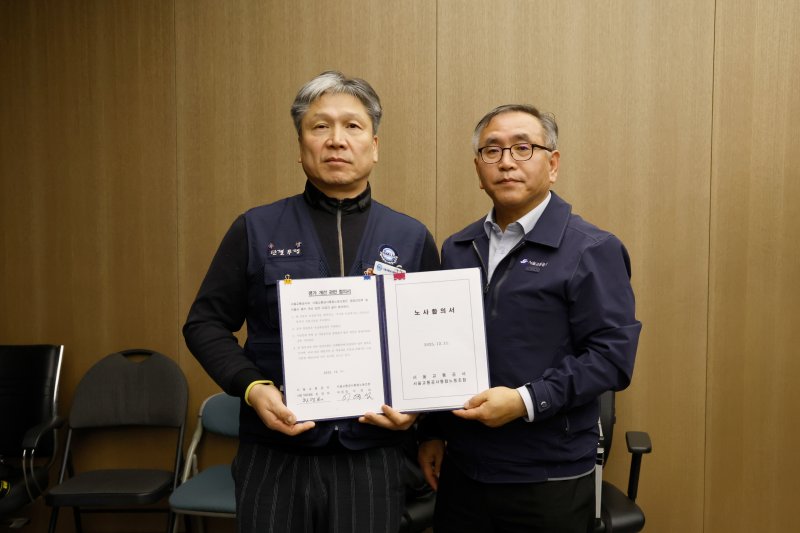 이양섭 서울교통공사통합노조 위원장(왼쪽)과 한영희 서울교통공사 기획본부장(사장 직무대행)이 12일 오전 서울 성동구 서울교통공사 본사에서 임금·단체협약 합의서를 체결한 뒤 기념촬영하고 있다. (서울교통공사 제공. 재판매 및 DB 금지) 2025.12.12/뉴스1 ⓒ News1 이호윤 기자