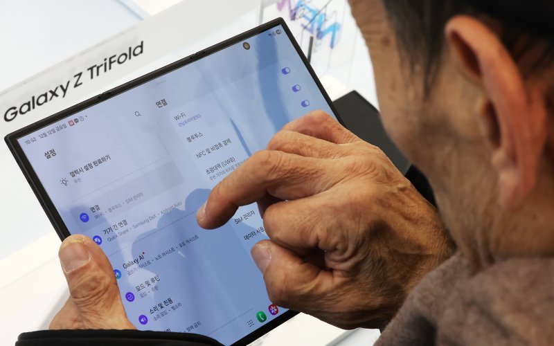 갤럭시 Z 트라이폴드가 출시된 12일 오전 서울 서초구 삼성 강남을 찾은 어르신이 제품을 살펴보고 있다. 2025.12.12/뉴스1 ⓒ News1 장수영 기자
