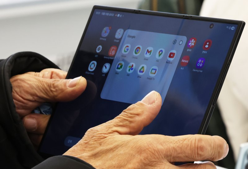 갤럭시 Z 트라이폴드가 출시된 12일 오전 서울 서초구 삼성 강남을 찾은 어르신이 제품을 살펴보고 있다. 2025.12.12/뉴스1 ⓒ News1 장수영 기자