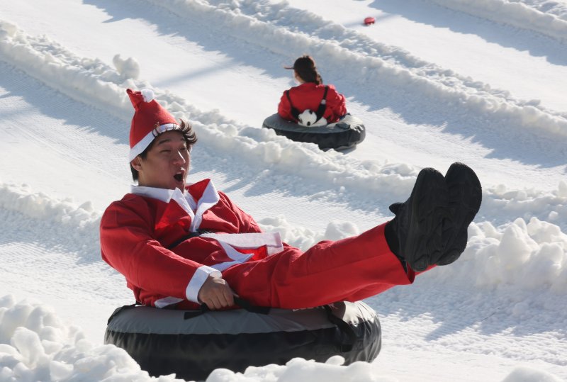 에버랜드 겨울 야외 액티비티 '스노우 버스터'가 개장한 12일 경기 용인시 처인구 에버랜드 눈썰매장 스노우 버스터에서 산타 복장을 한 직원들이 눈썰매를 타고 있다. 2025.12.12/뉴스1 ⓒ News1 김영운 기자