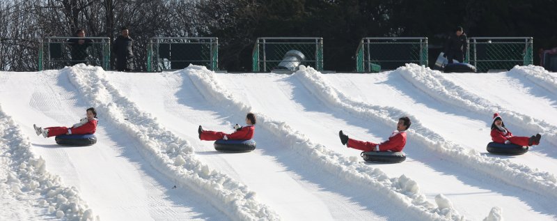 에버랜드 겨울 야외 액티비티 '스노우 버스터'가 개장한 12일 경기 용인시 처인구 에버랜드 눈썰매장 스노우 버스터에서 산타 복장을 한 직원들이 눈썰매를 타고 있다. 2025.12.12/뉴스1 ⓒ News1 김영운 기자