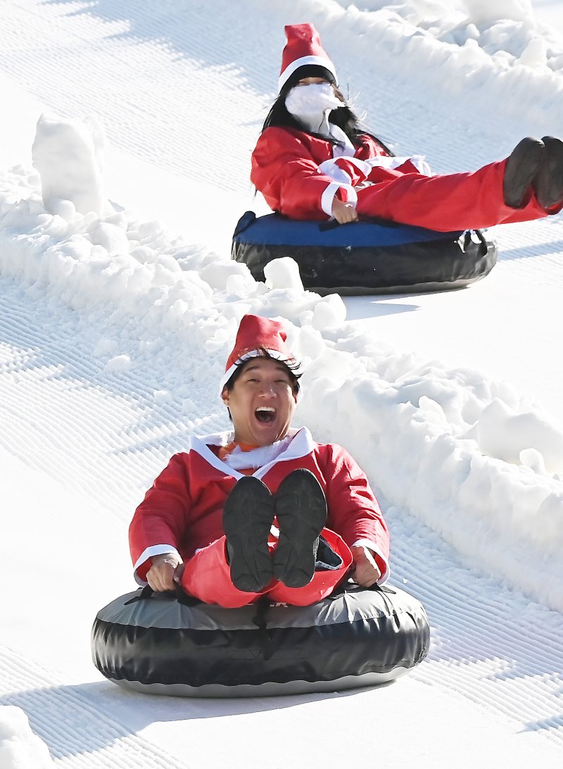 [용인=뉴시스] 김종택 기자 = 12일 경기 용인시 에버랜드 스노우버스터에서 산타복장을 한 시민들이 눈썰매를 타며 즐거운 시간을 보내고 있다. 2025.12.12. jtk@newsis.com