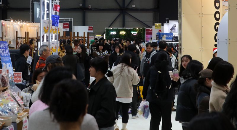 [서울=뉴시스] 김혜진 기자 = 12일 서울 강남구 세텍(SETEC)에서 열린 크리스마스 서울 펫쇼에서 관람객들이 반려견과 함께 전시장을 둘러보고 있다. 2025.12.12. jini@newsis.com